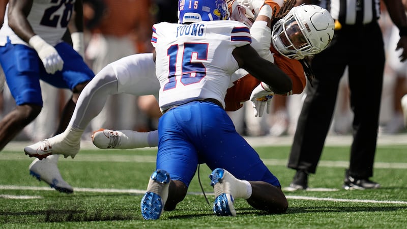 Texas running back Jonathon Brooks (24) is hit by Kansas linebacker Craig Young (15) during...