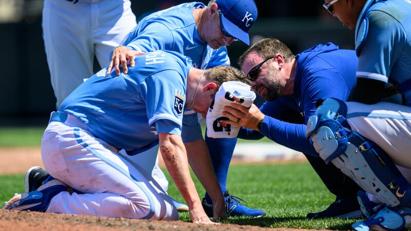 Kansas City Royals starting pitcher Ryan Yarbrough, front left, is tended to by training staff...