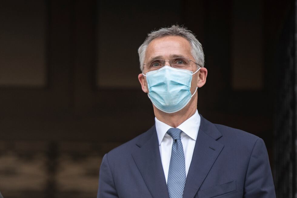 NATO Secretary-General Jens Stoltenberg, wearing a face mask stands next to Greek Prime...