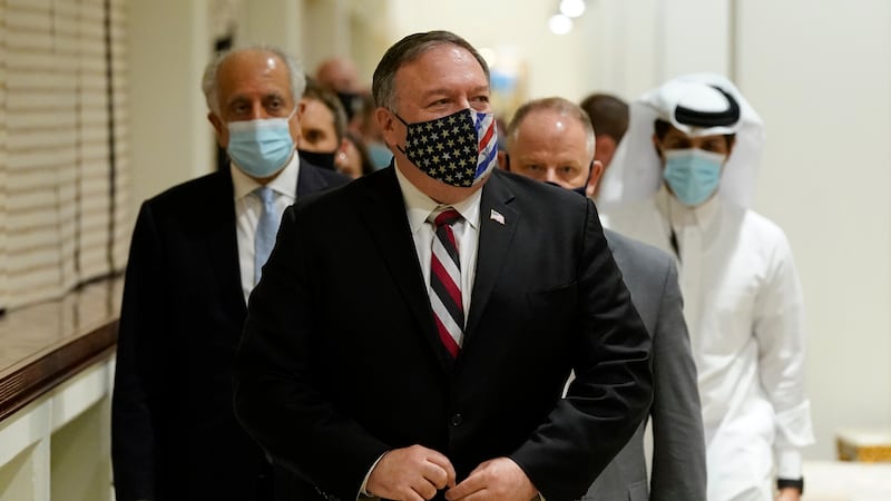 Secretary of State Mike Pompeo walks into a meeting with the Taliban's peace negotiation team...