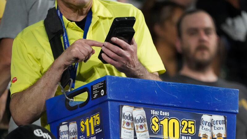 A beer vendor figures out the price for a baseball fan during a baseball game between the...
