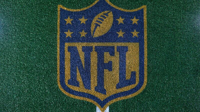 A detail view of the Gold NFL Logo Shield on field turf that is on display in Draft Town...