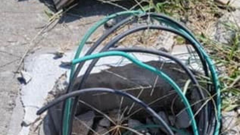 Crews examine a streetlight that has been stripped of copper wire and vandalized in Topeka on...