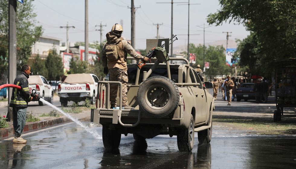 In this June 6, 2021 photo, Afghan security personnel leave the scene of a roadside bomb...