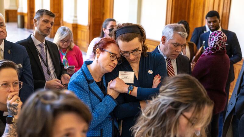 FILE - Jennifer Bowie, center left, and Aaron Baker, center right, become emotional while...