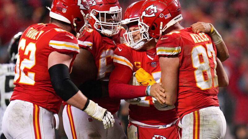 Kansas City Chiefs quarterback Patrick Mahomes (15) is helped by teammates after a play...