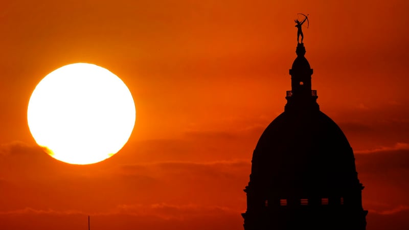FILE - The Kansas Statehouse stands against the sky as the sun sets in the distance Monday,...