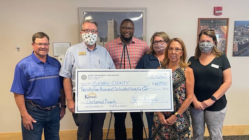State Treasurer Lynn Rogers presents a check of over $25,000 in unclaimed property to Geary...