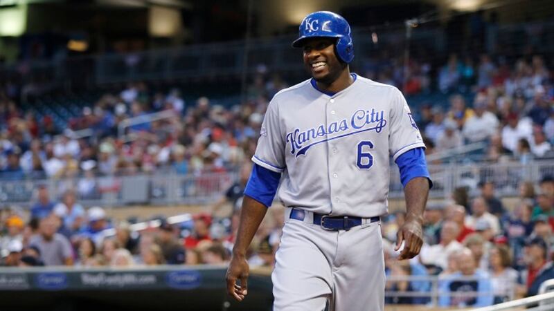 Kansas City Royals' Lorenzo Cain smiles as he heads to the dugout after scoring on a double by...